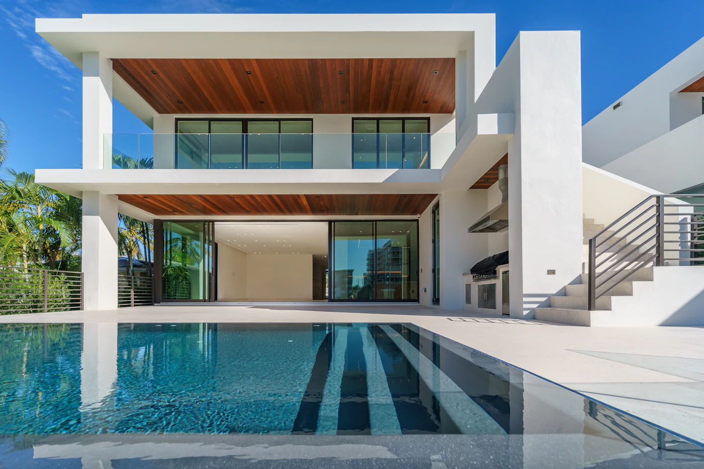 Residential backyard swimming pool beside a home